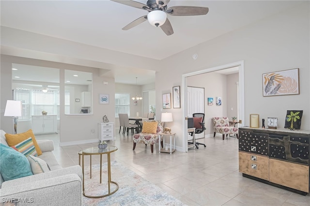 living room featuring a wealth of natural light, ceiling fan with notable chandelier, and light tile patterned floors