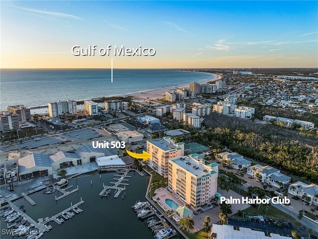 aerial view at dusk featuring a water view