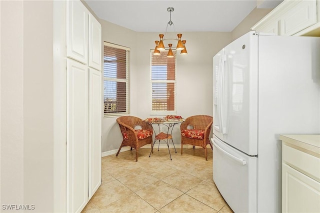 150 Lenell Rd Unit 503, Fort Myers Beach, FL 33931 - kitchen featuring white cabinets, a notable chandelier, freestanding refrigerator, decorative light fixtures, and light tile patterned floors