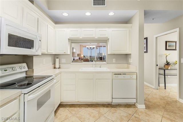 kitchen featuring white appliances, a notable chandelier, sink, white cabinets, and light tile patterned flooring