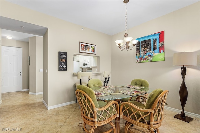 tiled dining room with a chandelier