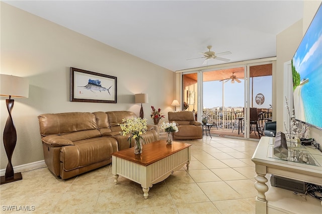 living room featuring ceiling fan, light tile patterned floors, and a wall of windows