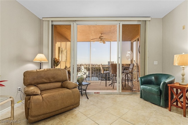 living area featuring expansive windows, light tile patterned floors, and ceiling fan