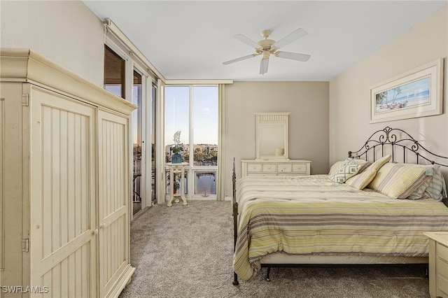 carpeted bedroom featuring ceiling fan, expansive windows, and access to exterior