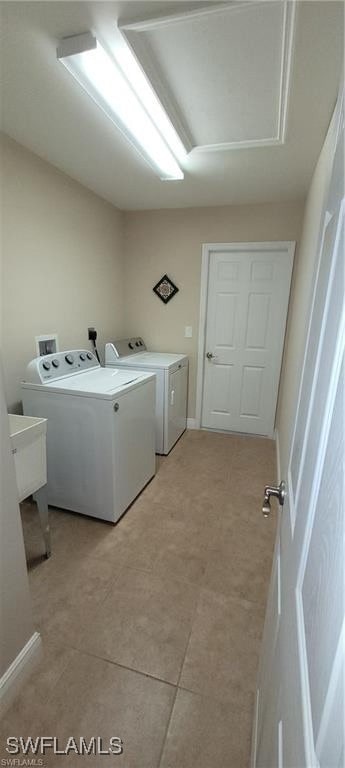 clothes washing area featuring washer and dryer and light tile patterned floors