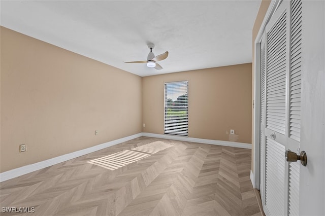 unfurnished bedroom with ceiling fan, a closet, and light parquet flooring