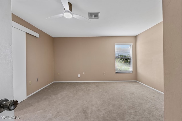 spare room featuring light carpet and ceiling fan