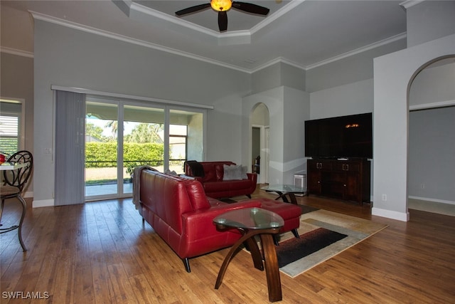 living room featuring a high ceiling, ceiling fan, hardwood / wood-style flooring, and ornamental molding