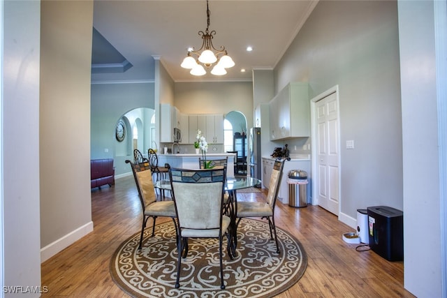 dining room featuring crown molding, a notable chandelier, and hardwood / wood-style floors