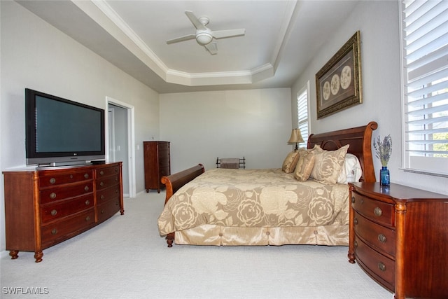 bedroom featuring crown molding, a raised ceiling, light colored carpet, and ceiling fan