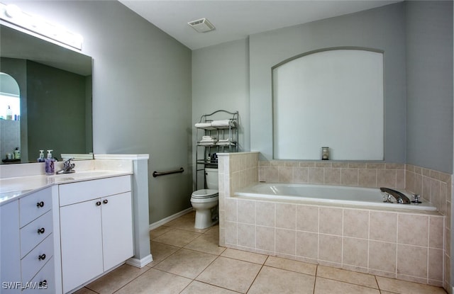 bathroom with vanity, toilet, tile patterned floors, and a relaxing tiled tub