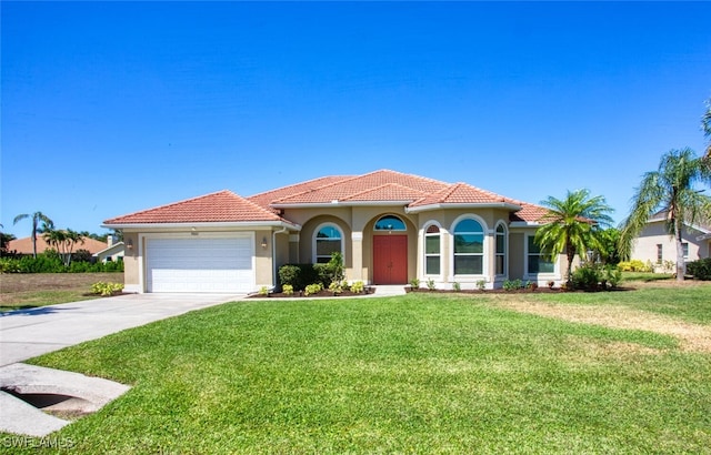 mediterranean / spanish home with a garage and a front lawn