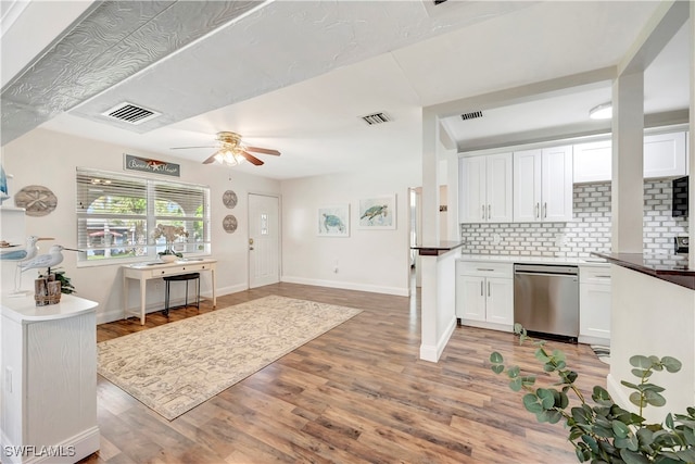 kitchen with white cabinets, backsplash, dishwasher, light hardwood / wood-style floors, and ceiling fan