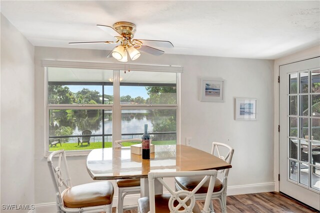 dining space featuring a water view, ceiling fan, and hardwood / wood-style flooring