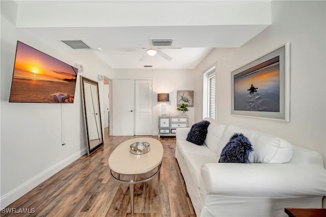 living room featuring wood-type flooring and ceiling fan