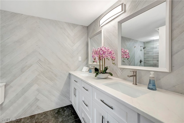 bathroom featuring vanity, a tile shower, and parquet flooring