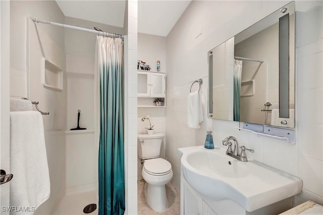 bathroom with tile walls, toilet, vanity, and a shower with shower curtain