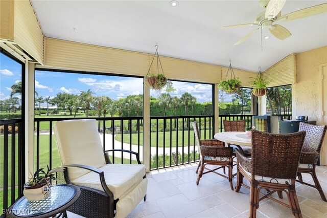 sunroom / solarium featuring vaulted ceiling, a healthy amount of sunlight, and ceiling fan