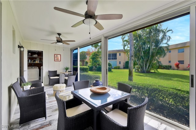 sunroom with ceiling fan and washer / dryer