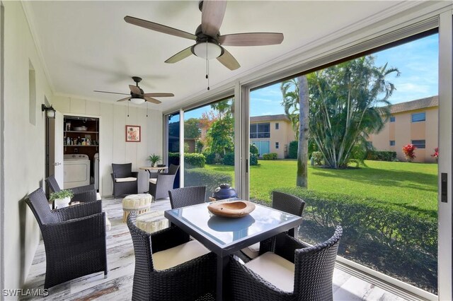 sunroom featuring ornamental molding, wood finished floors, and washer / clothes dryer
