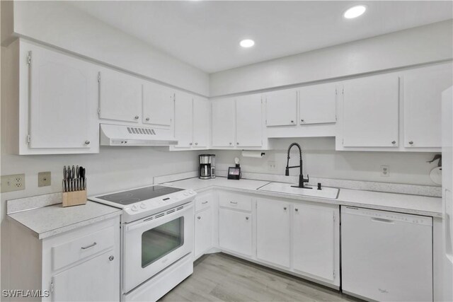 kitchen featuring a sink, white cabinets, white appliances, under cabinet range hood, and light countertops