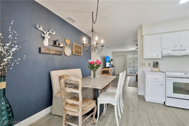 dining space with baseboards, light wood-style floors, an inviting chandelier, and visible vents