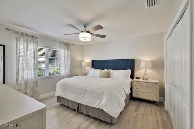 bedroom with a closet, visible vents, light wood-style flooring, a ceiling fan, and baseboards