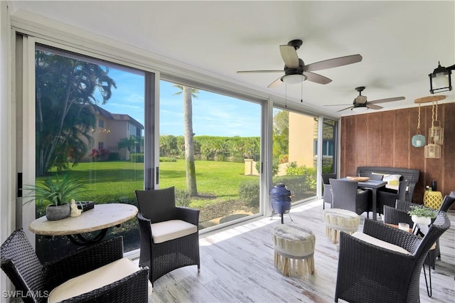 sunroom / solarium with a ceiling fan, outdoor dining area, and plenty of natural light