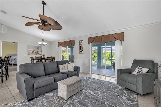 tiled living room with ceiling fan with notable chandelier and vaulted ceiling