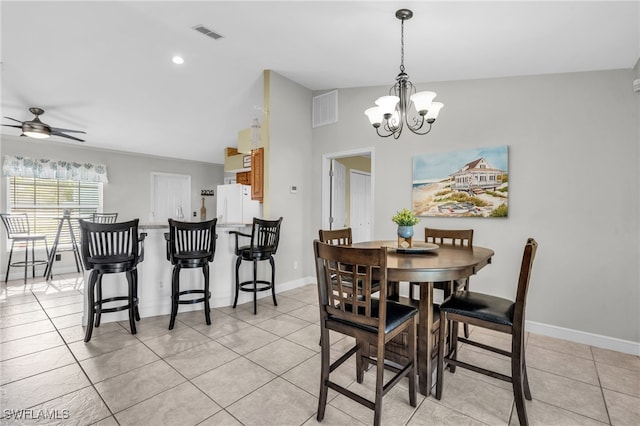 tiled dining area featuring ceiling fan with notable chandelier and lofted ceiling