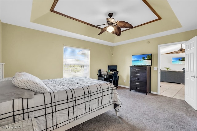 bedroom with light carpet, a raised ceiling, and ceiling fan