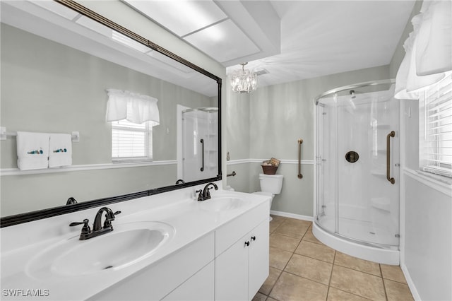 bathroom with tile patterned flooring, vanity, a shower with door, and a chandelier