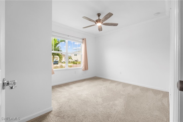 carpeted spare room featuring crown molding and ceiling fan