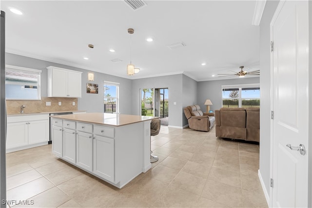 kitchen with white cabinetry, tasteful backsplash, a center island, and a wealth of natural light