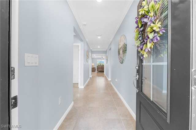 corridor featuring ornamental molding and light tile patterned floors