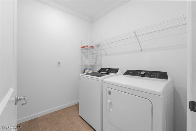 laundry room featuring crown molding, washer and clothes dryer, and light tile patterned floors