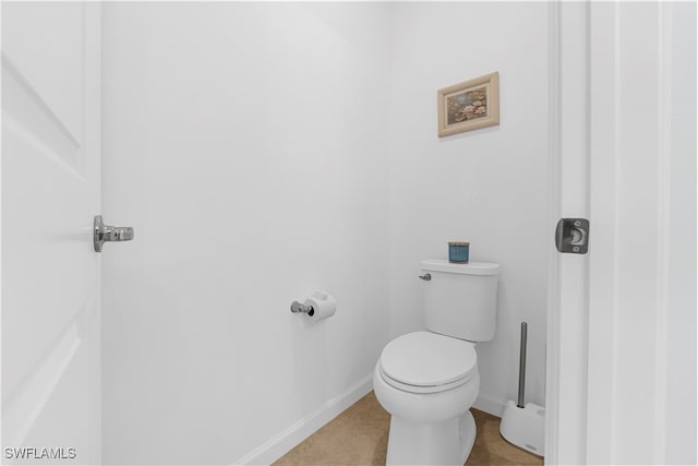 bathroom with toilet and tile patterned flooring