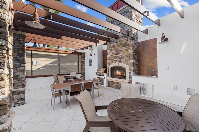 view of patio / terrace featuring an outdoor stone fireplace, a grill, and a pergola