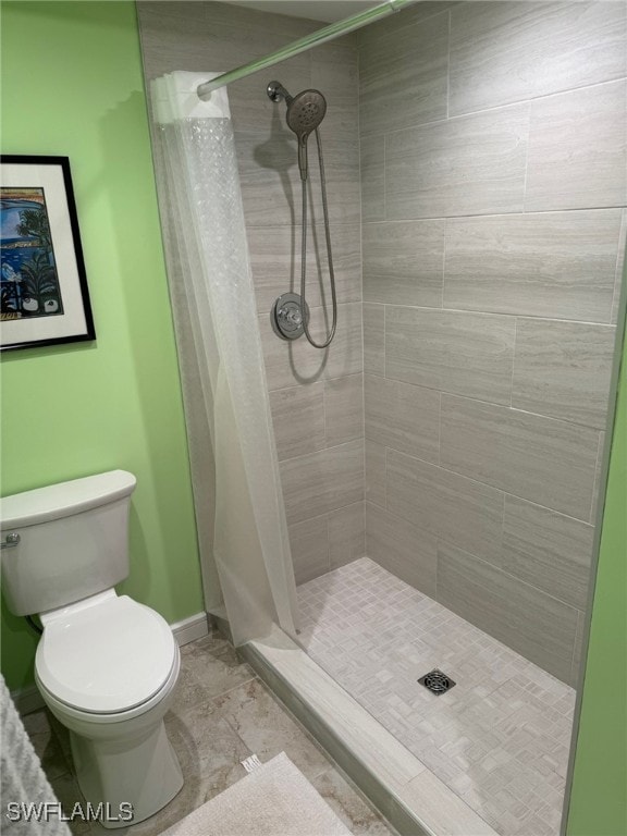 bathroom featuring toilet and curtained shower