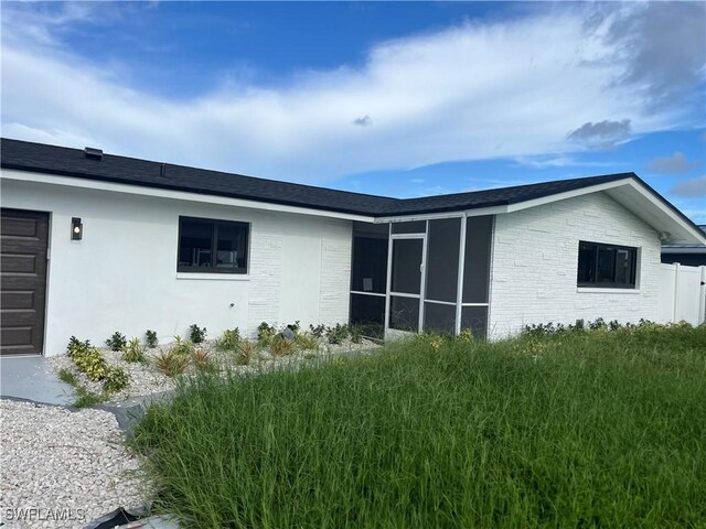 view of home's exterior with a sunroom