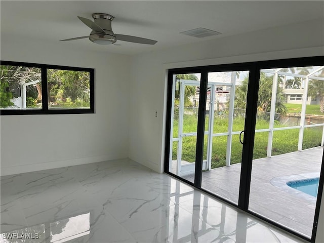 doorway with marble finish floor, a ceiling fan, visible vents, and baseboards