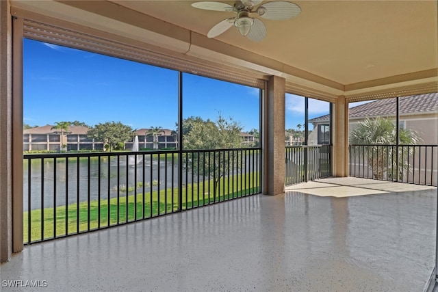 unfurnished sunroom with ceiling fan and a water view