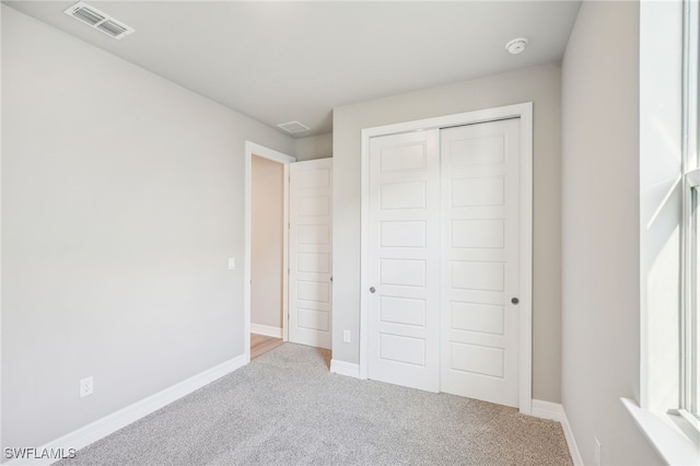 unfurnished bedroom with carpet floors and a closet