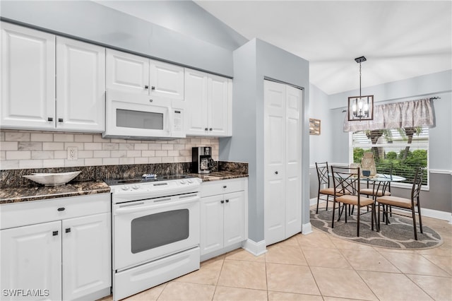 kitchen with hanging light fixtures, white appliances, white cabinetry, and lofted ceiling