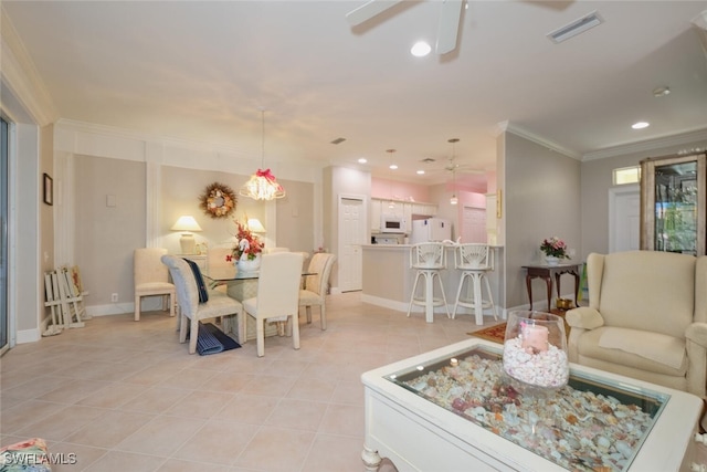 tiled dining room featuring ceiling fan and crown molding