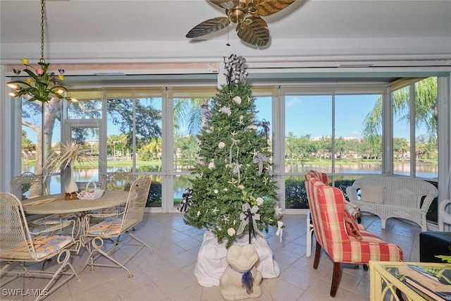 sunroom / solarium with a wealth of natural light, ceiling fan, and a water view