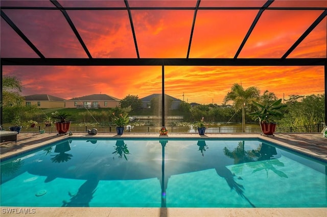 pool at dusk with a patio area