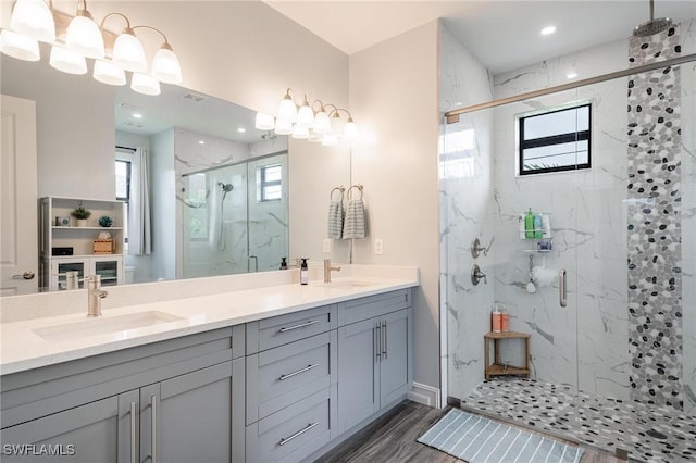 bathroom featuring hardwood / wood-style floors, vanity, and a shower with shower door