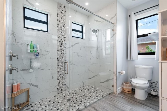 bathroom featuring wood-type flooring, an enclosed shower, and toilet