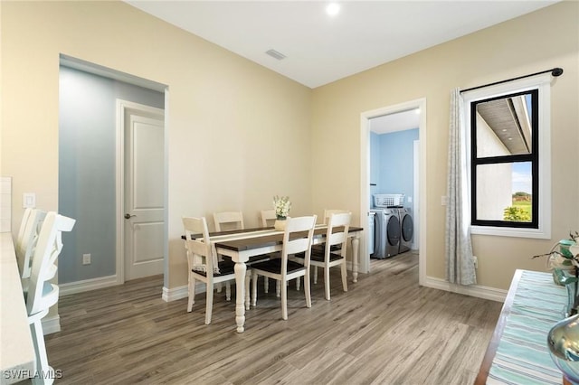 dining area featuring wood-type flooring and independent washer and dryer